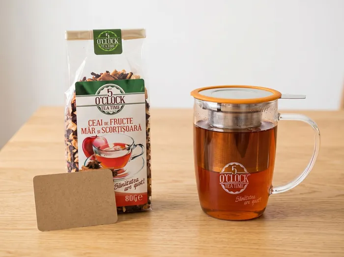 cadou corporate ceai și cană: pungă Măr și Scorțișoară 80 g lângă o cană cu infuzor 5 O'Clock Tea