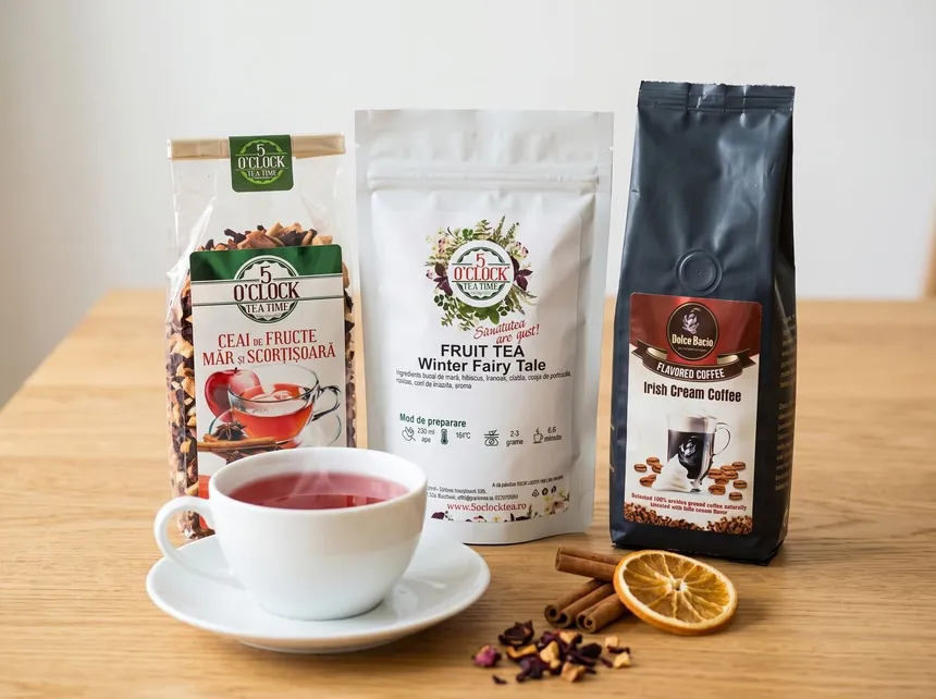 cadou corporate cu ceai și cafea: Măr și Scorțișoară 40 g, Winter Fairy Tale 50 g și Irish Cream Coffee 125 g pe masă, cu o cană